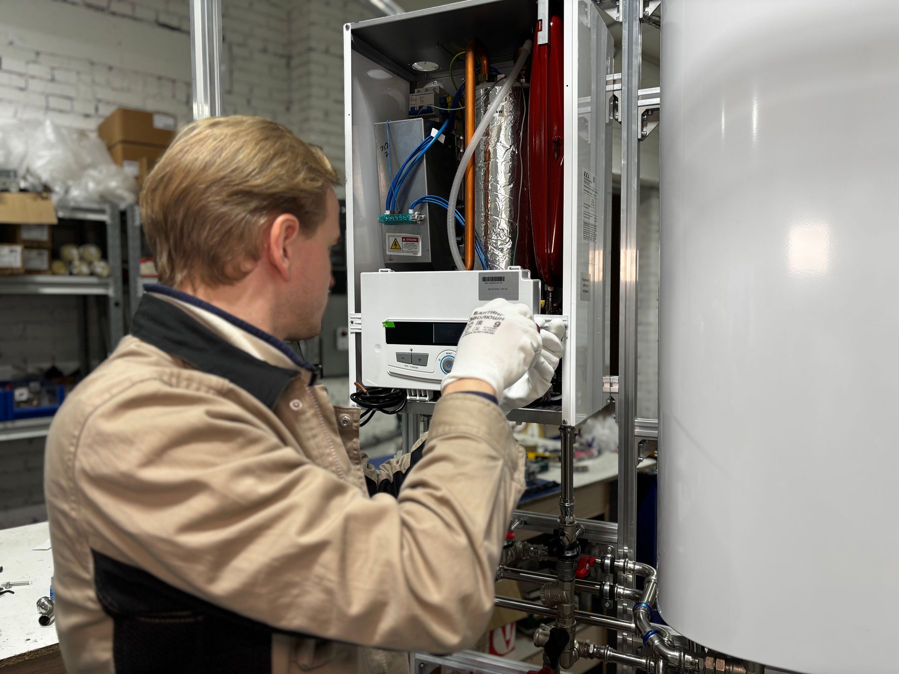 A technician servicing boiler controls and heating equipment